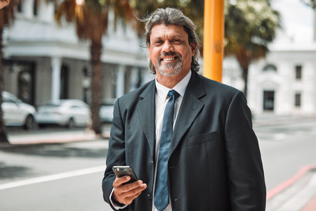Portrait, business and senior man with a smartphone, city and smile with connection, typing and social media. Face, male person outdoor and consultant with a cellphone, connectivity and mobile appの写真素材