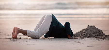 Search, digging and a man in the beach sand in nature for travel fun or holiday adventure in summer. Earth, looking and a person with a check in the ground at the ocean for treasure on vacationの写真素材