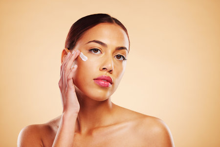 Skincare, portrait or woman with face cream or sunscreen product in grooming routine with cosmetics. Dermatology, studio background or beauty model applying natural facial creme lotion moisturizerの写真素材