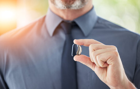 Hearing aid, hands and business man with disability for communication support, listening and medical...