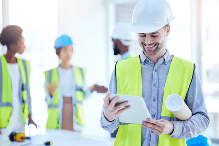 Construction worker, tablet and man with blueprint of engineer, builder or contractor. Industrial, handyman app and male person with digital info and smile from engineering and architecture projectの写真素材