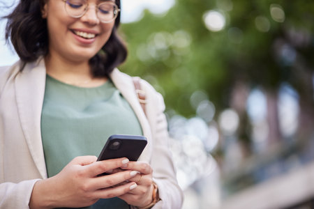 Reading, business woman and cellphone in outdoor for networking with communication on online app. Professional female, technology and typing on social media for information on website for career.の写真素材