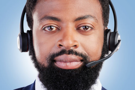 Customer service portrait, studio black man and serious consultant for tech support, help desk administration or telecom. Call center profile picture, face and African person face on blue backgroundの写真素材