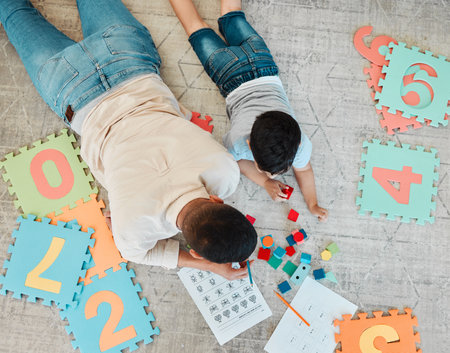 Building blocks, top or father with kid on the floor for learning, education or child development at home. Family, play or dad enjoying bonding time in living room with boy or toys doing homeworkの写真素材
