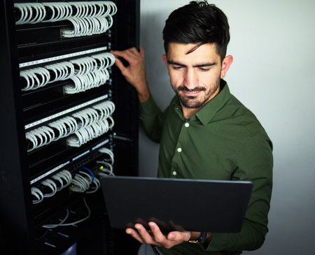 Laptop, data center and male technician in a server room for technical repairs by a control box....