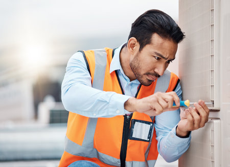 Tools, engineering and man with air conditioner panel for repair, maintenance and inspection on roof. Heating, technician and male worker with equipment for service, installation or electricity checkの写真素材