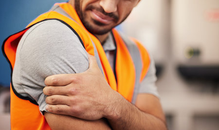 Hand, construction worker and arm pain from building, handyman injury or maintenance stress. Sad, safety and a person with inflammation, medical emergency or a problem while working on a siteの写真素材
