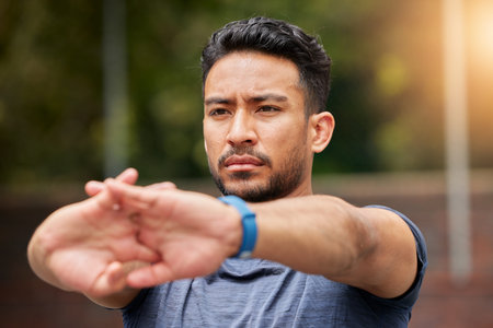 Serious, fitness or man stretching arms in exercise, training or healthy sports outdoor. Face of...