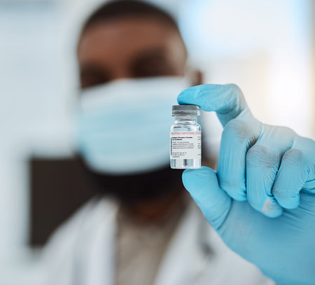 Medicine, vaccine and a hand of a doctor with gloves for virus protection, healthcare or cure in hospital. Person with pharmaceutical product, vial or container for treatment, solution or preventionの写真素材