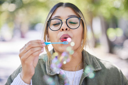 Face of woman blowing bubbles in park, garden and freedom for fun, good mood and carefree...