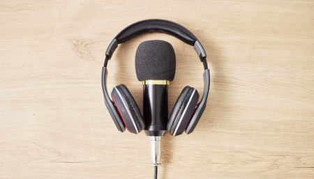 Audio, microphone and headphones on a table for a podcast, radio or broadcast. Music, above or...
