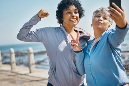 Mature women, friends and outdoor for peace selfie with fitness, motivation and travel memory. Profile picture, social media and influencer people with smile, adventure and flex arm for strong powerの写真素材