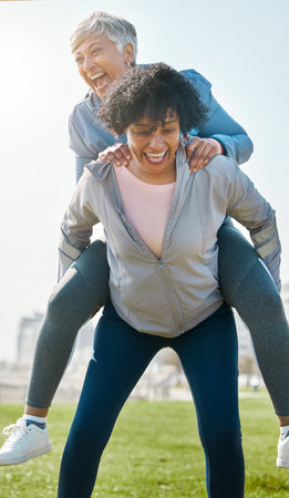 City, funny and senior friends piggy back together or women playing, crazy and laughing after outdoor exercise. Health, wellness and goofy elderly people bonding with humor or comedy after workoutの写真素材