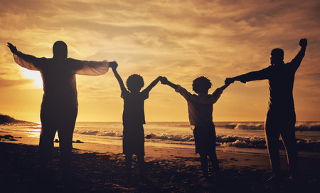 Holding hands, sunset and silhouette of a family at the beach with love, freedom and happiness. Summer, travel and back of parents with children, affection and together in the dark by the oceanの写真素材