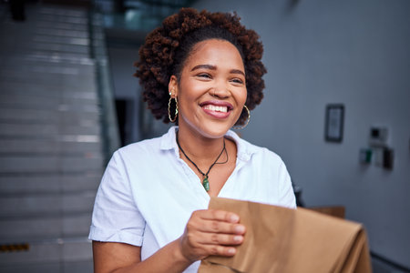 Delivery, happy customer and a woman at a door with a paper bag from courier at home. Face of a person or a client with a package, parcel or fast food from online shopping, e-commerce or serviceの写真素材