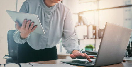 Tablet, laptop and business woman hands at web analyst company with typing. Technology, female person and online professional working in a office with computer and digital data research for projectの写真素材