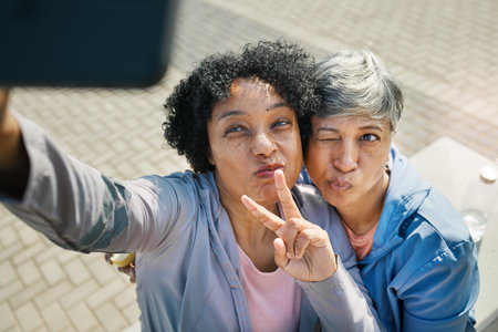 Senior women, selfie and peace, hands and wink in a city for travel, fun and chilling on the weekend outdoor. Face, friends and old ladies pose for profile picture, photo or traveling memory in townの写真素材
