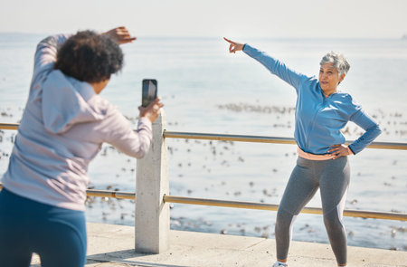 Phone, friends and photo of senior woman pointing at beach with silly pose at sea for fitness....