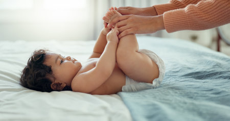 Care, happy and mother with baby on bed for playful, love and free time. Happiness, smile and health with woman and newborn infant in bedroom for family home for support, excited and youthの写真素材