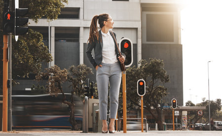 City, walking and woman on a crosswalk wait with travel, business commute and urban journey. Road, outdoor and female professional in morning traveling for work, career and job in New York on streetの写真素材