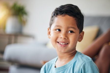 Kid, smile and happy in family home in the morning with thinking feeling relax in living room. Lens flare, face and house with young child, boy and cute son from Brazil on weekend with joy and youthの写真素材