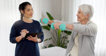 Physiotherapy tablet, senior happy woman and dumbbell workout, good healthcare results or rehabilitation assessment test. Physical therapy, support or physiotherapist monitor arm exercise of clientの写真素材