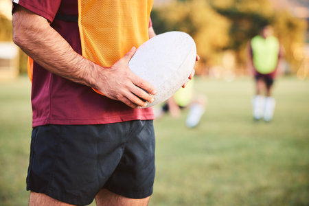 Rugby, man and hands with ball for sports games, competition and contest on field. Closeup of athlete, team player and training at stadium for fitness, exercise and performance of challenge outdoorの写真素材