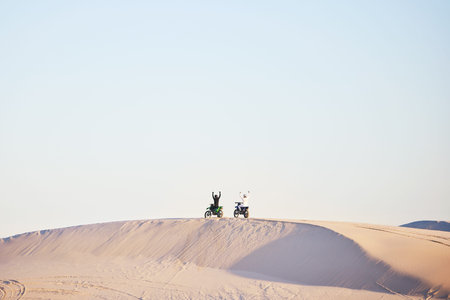 Motorbike, race celebration and desert on sand, competition or outdoor hill for sky background, goal or off road. Motorcycle athlete, ramp and nature with win, success and contest with mockup spaceの写真素材
