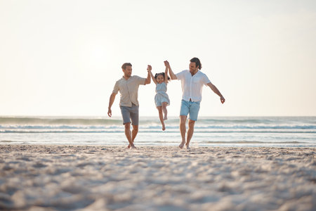 Gay couple, playing and holding hands with family at beach for seaside holiday, support and travel. Summer, vacation and love with men and child in nature for lgbtq, happiness and bonding togetherの写真素材