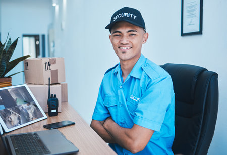 Security guard man, portrait and smile to monitor with laptop, tablet and arms crossed in control room. Young safety officer, surveillance expert and happy for job, protection service and computerの写真素材