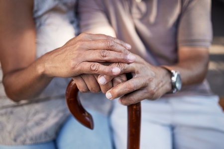 Senior couple, hands and cane in support, retirement and solidarity in marriage. Walking stick, people with a disability and man and woman in comfort, trust or love, care or empathy in house togetherの写真素材