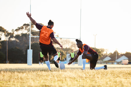 Rugby, kick and sport game with support, exercise and competition with athlete ball training. Field, back and target practice on grass with cardio, fitness and team workout outdoor for teamworkの写真素材