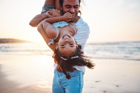 Beach, portrait and father play with girl on holiday, vacation and adventure at sunset. Happy family, summer and child laughing with dad by ocean for bonding, healthy relationship and fun outdoorsの写真素材