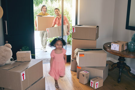 Happy, family run and box moving with child and gay parents in new home with cardboard package. Smile, kid and lgbt people together with real estate and property love in a house helping fatherの写真素材