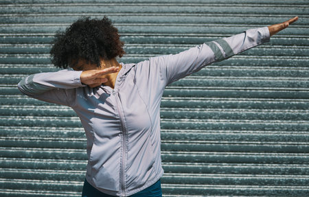 Dabbing, dance and a person on a city wall for hip hop, celebration or fitness. Urban, sports and a...