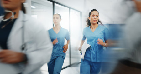 Doctors, nurses or running in hospital emergency, patient crisis or pager call in ICU stress, trauma fail or diversity clinic. Healthcare women, rushing or run in medical hallway to code blue problemの写真素材
