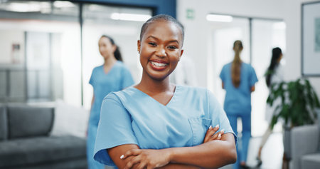 Nurse, face or arms crossed in busy hospital for about us, medical life insurance or wellness support. Smile, happy or healthcare black woman in portrait, confidence trust or help medicine internshipの写真素材