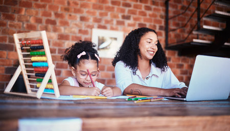 Remote work, home and a mother and child with homework or a laptop for typing an email. Happy, table and a young mom with a computer for freelance job and a girl kid drawing or writing for educationの写真素材