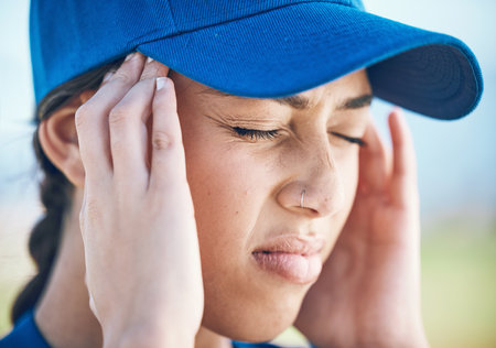 Woman, baseball and headache in stress, mistake or burnout from sports injury or outdoor accident. Upset female person, player or athlete with migraine, tension or strain under pressure on the fieldの写真素材