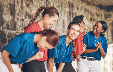 Sports team, people or friends laughing together with for fitness, competition or game. Diversity, happy and group of women in a dugout for baseball, training or communication or funny conversationの写真素材
