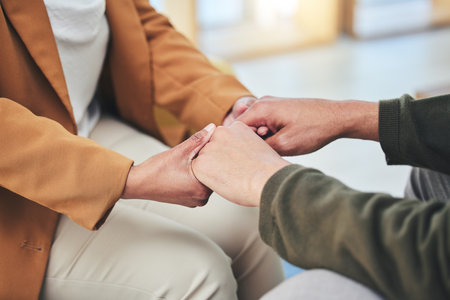 Support, mental health and patient holding hands with therapist in counseling session for depression, anxiety or trauma. Person, talking and psychologist listening with empathy, kindness or helpingの写真素材