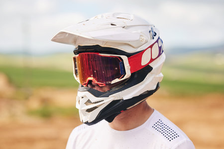 Sports, motorcycle and man with helmet in the countryside for fitness, practice or speed training. Motorbike, safety and male driver with head gear, protection and neon glasses for off road adventureの写真素材