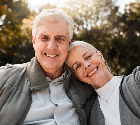 Love, portrait and senior couple hug in a forest, happy and bond in nature on a weekend trip together. Smile, face and romantic old woman embrace elderly male in woods, cheerful and enjoy retirementの写真素材