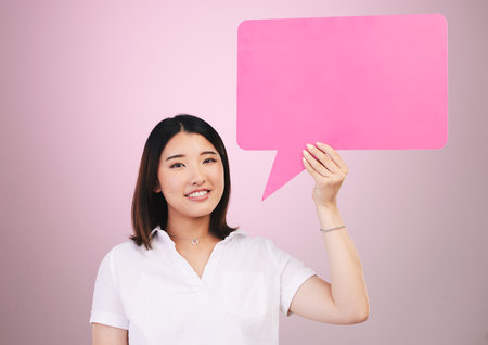 Woman, beauty and speech bubble for communication, skincare forum or cosmetics on pink background. Portrait of asian person with dermatology opinion, questions and chat or FAQ poster mockup in studioの写真素材