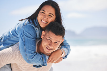 Summer, piggyback and portrait of a couple at the beach for a date, love or vacation together. Mockup, smile and a man and woman with a hug at the sea for a holiday, travel or bonding in marriageの写真素材