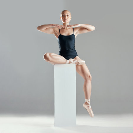 Balance, ballet or portrait of woman in studio on platform in elegant performance or creative freedom. Art, dancer or girl ballerina ready to start dancing or training to exercise on white backgroundの写真素材
