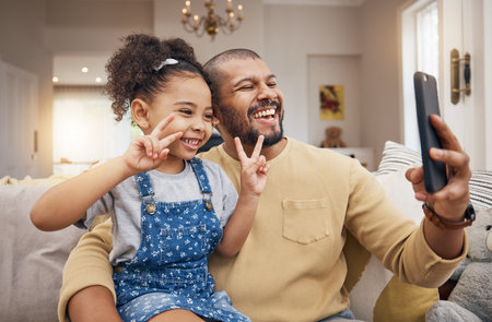 Selfie, happy and a father and child with a peace sign on the sofa for social media or a video call. Smile, family and a dad taking a photo with a girl kid and a gesture for live streaming in a houseの写真素材