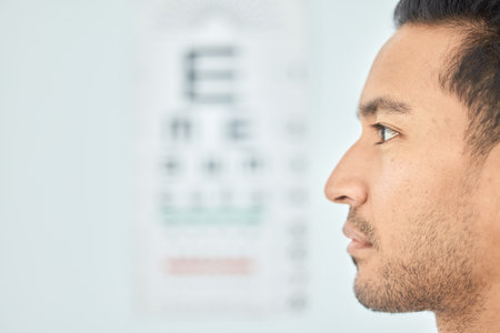 Man, face and clinic eye exam for vision, optometry and wellness for prescription lens on space. Closeup person, thinking and serious patient in optometry, ophthalmology and assessment for eyesightの写真素材