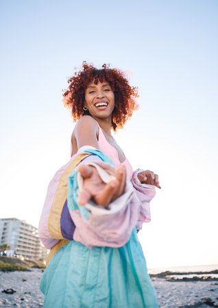 Portrait smile, woman and helping hand, offer or invitation at beach in low angle mockup space. Happy, palm and African person giving assistance in support, care or acceptance of handshake to welcomeの写真素材