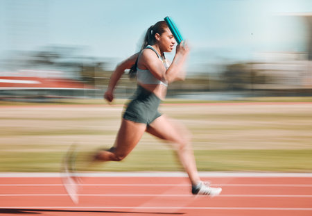 Action, speed and woman athlete running relay sprint in competition for fitness game and training for energy wellness on a track. Sports, stadium and athletic person or runner exercise and workoutの写真素材